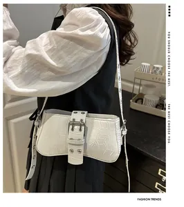 Detail of white crocodile pattern shoulder bag with silver eyelets and buckle strap