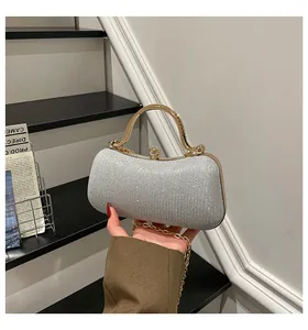 Nahaufnahme der silbernen Pailletten-Abendtasche mit goldenem Metallgriff und Kristallverschluss
