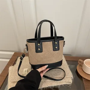 Retro canvas and leather bucket bag with quilted stitching and gold rivet details