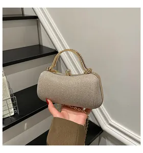 Detail der champagnergoldenen Abendtasche mit funkelnden Strasssteinen und Metallgriff