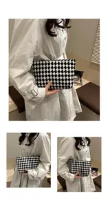 Detailed close-up of a black and white diamond pattern woven tweed clutch bag