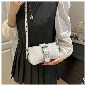 Detail of white crocodile pattern underarm bag with decorative metal buckle and strap