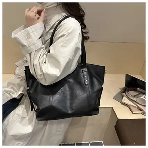 Detail of black PU leather tote bag featuring star rivets and large laptop capacity