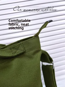 Detail of army green canvas tote bag showing neat stitching and metal adjustment buckle