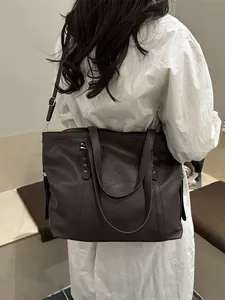 Brown faux leather tote bag with pebble texture and adjustable shoulder strap