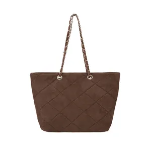 Classic dark brown suede quilted tote bag with gold chain strap on white background