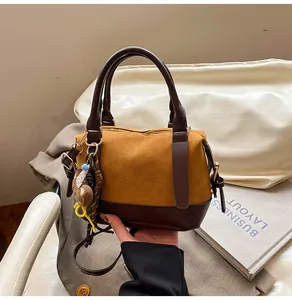 Détail du sac bowling bandoulière en daim jaune avec un joli pendentif en forme d'ours