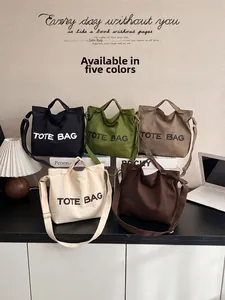 Five canvas tote bags in different colors shown with adjustable shoulder straps