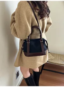 Détail du sac bowling vintage en toile avec garniture en cuir marron et boucles dorées