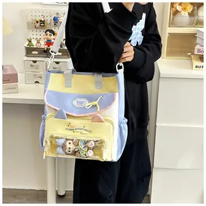 Detailansicht der bunten Canvas Ita-Tasche mit Klarsichtfach und Plüschbär-Anhänger