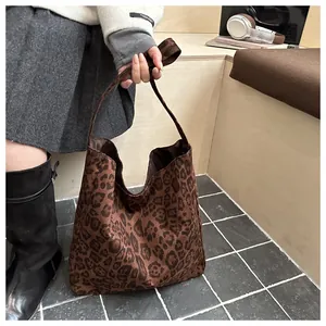 Détail d'un grand sac cabas imprimé léopard en peluche marron avec une bandoulière douce