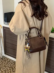 Sac bandoulière bowling rétro en cuir marron et daim avec un pendentif d'ours