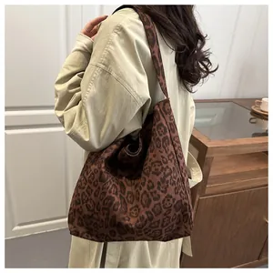 Gros plan d'un sac cabas léopard sur modèle montrant sa grande capacité et son style