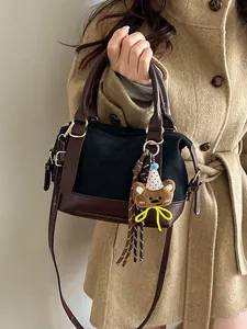 Sac bandoulière bowling rétro en toile noire et cuir marron avec bandoulière fine