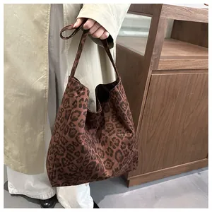 Détail du sac cabas imprimé léopard vintage porté avec un trench-coat d'automne chic