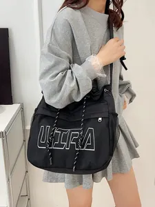 Black casual nylon crossbody bag with ULTRA lettering and mesh side pocket shown on model