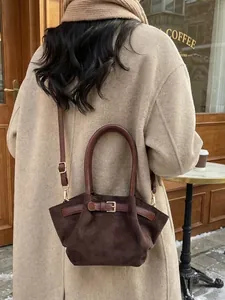 Retro dark brown suede bucket bag with leather handles shown in a winter street setting