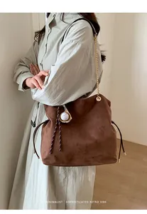 Borsa a secchiello in scamosciato marrone con tracolla a catena e charm baseball