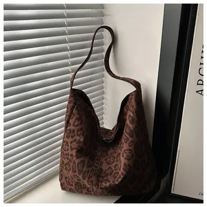 Gros plan sur la texture léopard du sac fourre-tout spacieux avec sa bandoulière