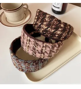 Trois serre-têtes en tweed texturé aux motifs à carreaux sur un plateau crème