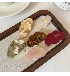 Détail de six barrettes nuage en acétate aux motifs marbrés et nacrés élégants