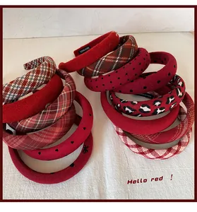 Close-up of handmade red tweed hairbands with detailed HAND MADE woven inner labels