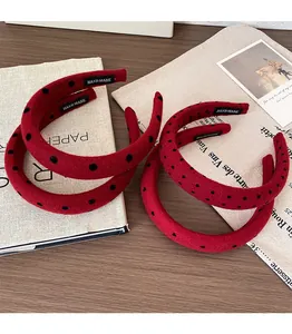 Close-up of handmade red polka dot velvet headbands with vintage handmade inner label