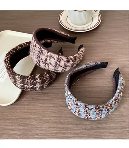 Détail de serre-têtes en maille rayée avec texture tweed sur une table en bois
