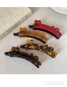 Dettaglio di quattro fermagli a banana a forma di gatto fatti a mano con finiture marmoree