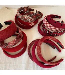 Detailed view of handmade red festive headbands with plaid and velvet textures