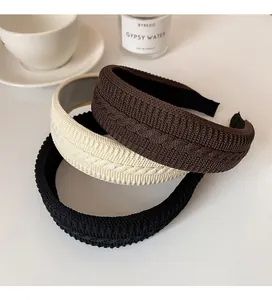 Detailed knit texture of vintage braided headbands in black, brown, and cream white