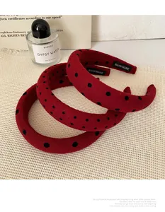 Detail of red polka dot velvet headbands with handmade label on textured fabric
