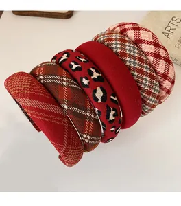 Close-up of six retro red plaid and leopard print sponge headbands on a table