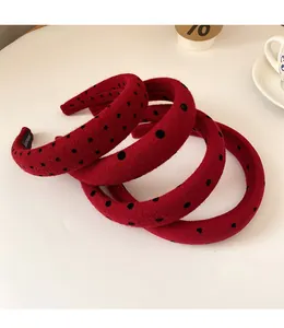 Detail of red polka dot hairbands with heart patterns and handmade label on white desk