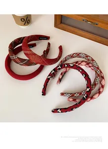 Close-up of assorted red plaid and leopard print padded headbands with handmade labels