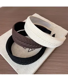 Detailed knit texture on thick braided headbands in black, brown and beige colors