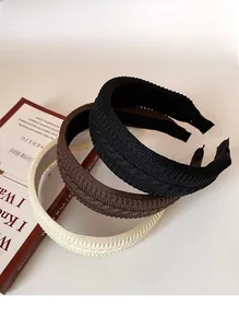 Close-up of thick knitted braided headbands in black, coffee, and beige colors