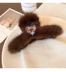 Detail of plush brown leopard hair claw clip with a houndstooth heart on a white plate