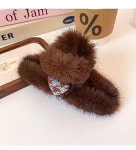 Detail of plush leopard heart claw clip showing brown faux fur and houndstooth pattern