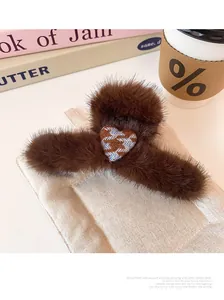Macro detail of plush leopard heart claw clip with houndstooth knit accent and soft faux fur