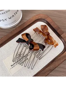 Dettaglio di pettini per capelli con fiocco francese in ambra e caffè scuro tartarugato