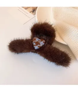 Detailed close-up of brown plush hair claw clip with blue houndstooth heart pattern
