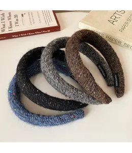 Gros plan de bandeaux tricotés épais à paillettes en bleu, noir, gris et marron