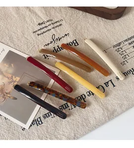 Detailed macro shot of slim acetate hair clips showing the golden France Handmade text