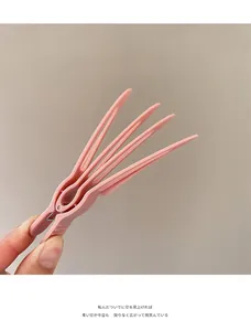 Close-up of pink matte hair root clip for volume with multi-tooth design in hand