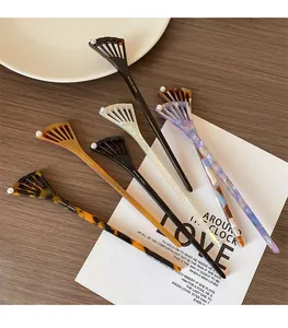Detailed view of handmade acetate hair sticks with hollow fan design and white pearl inlay