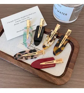 Detailed close-up of six assorted acetate hair clips with Creation France gold lettering