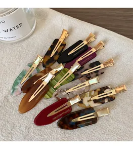 Detail of colorful acetate hair clips with Creation France engraving on metal base