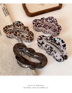 Close-up of four cloud-shaped hair claw clips in leopard and tortoiseshell patterns