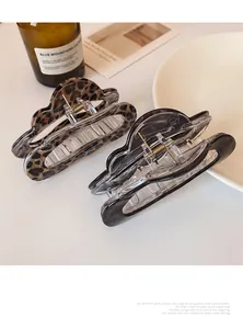 Close-up of leopard print and marble ink pattern hair claws with metal springs